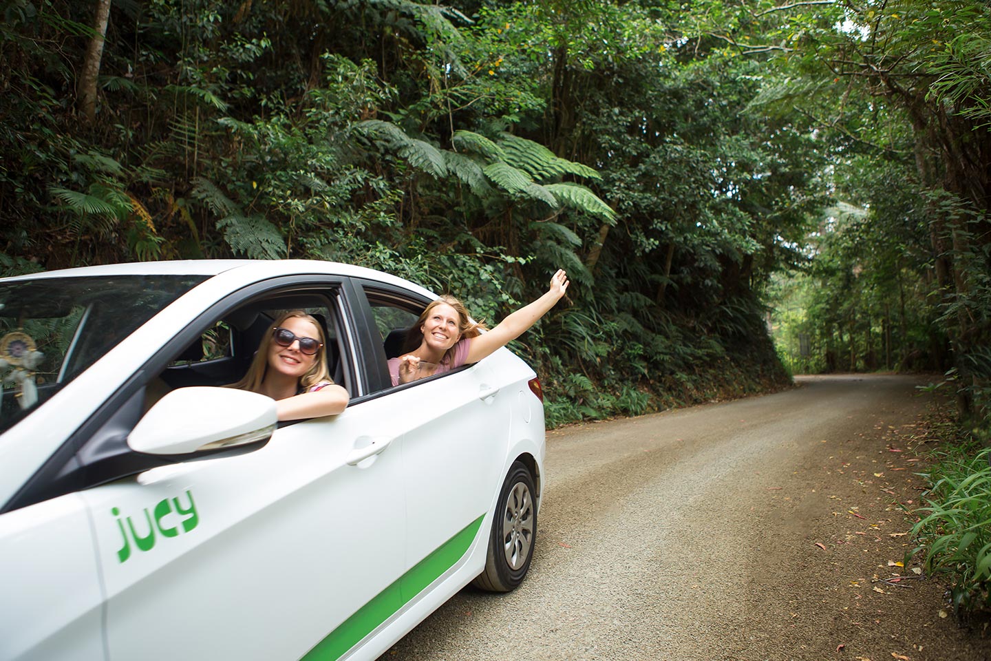 friends driving through forest road having fun