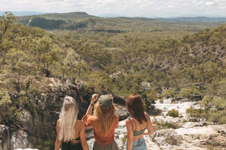 girls taking a photo at emerald creek falls in queensland