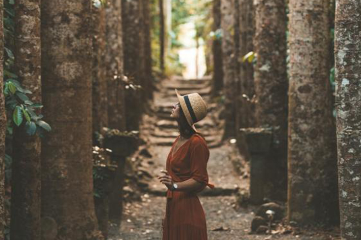 Girl walking between trees