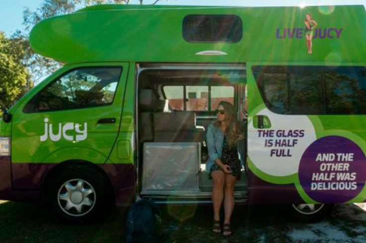 Girl sitting in a JUCY campervan