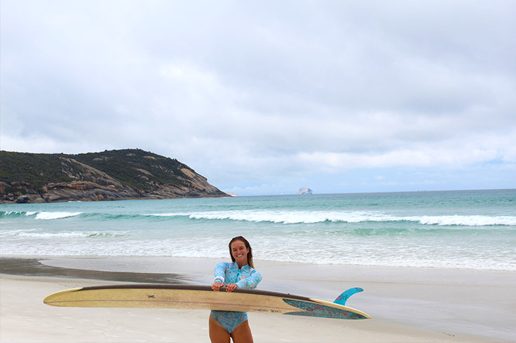 girl-at-squeaky-beach-with-surfboard