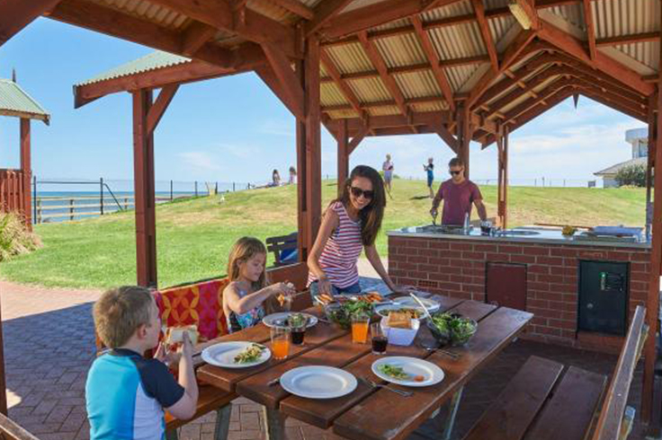 Family having a BBQ in a camp kitchen