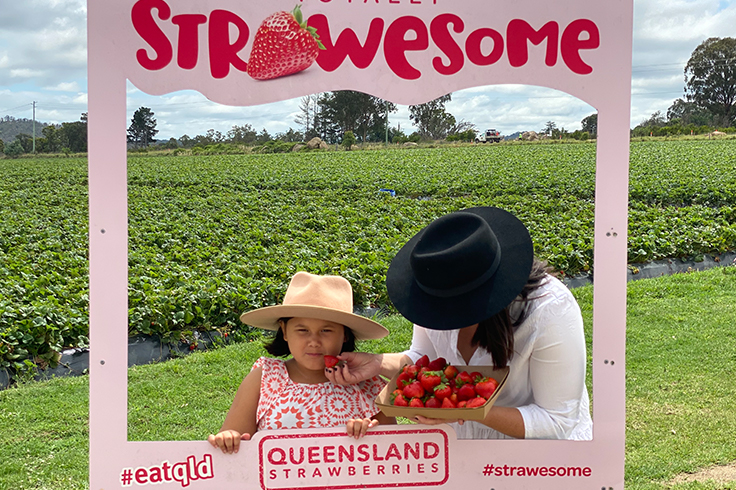 mother and daughter eating strawberries