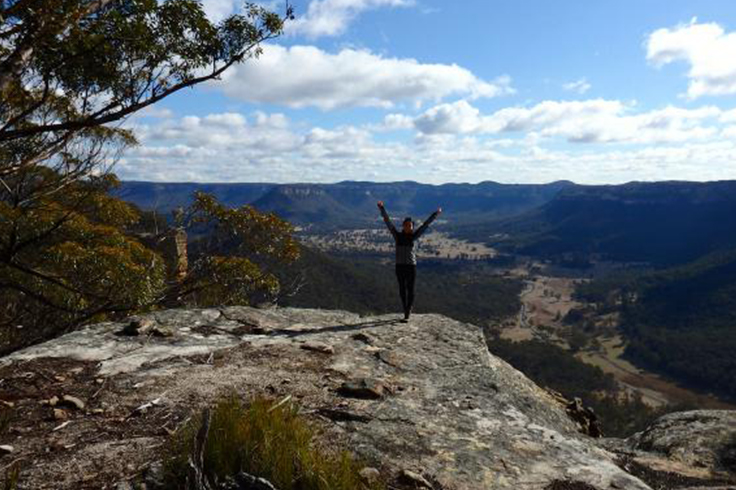 Girl celebrating at the top of a mountain