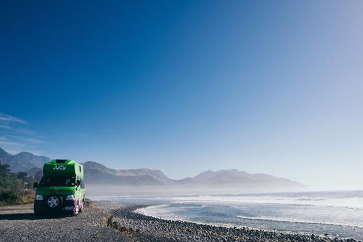 jucy campervan parked on a quiet beach in Zelandia