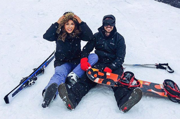 Couple sitting in ski field