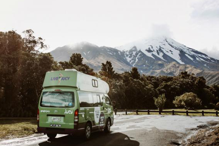 JUCY camper parked near mountains